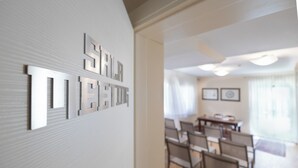A modern interior with a wall-mounted sign reading "SILVER STAR HOTEL" and a dining area with chairs and a table. - Hotel Bernardino (Lucca)