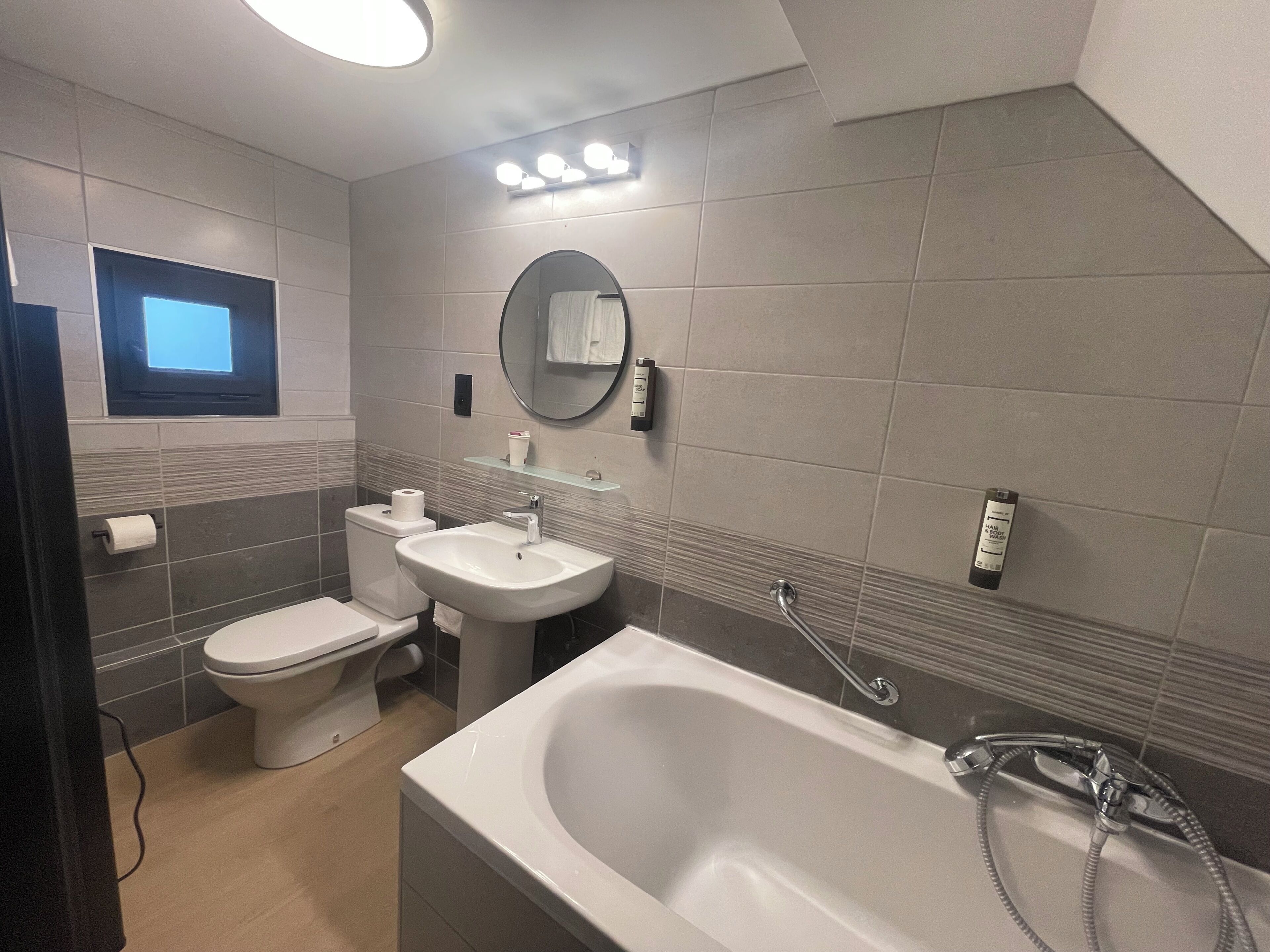 A modern bathroom with a toilet, sink, and bathtub.