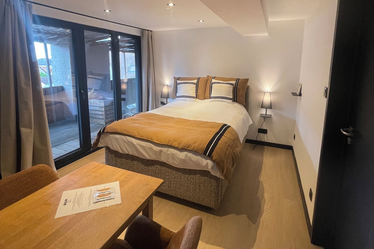 Una habitación de hotel con una cama, un escritorio y una silla.