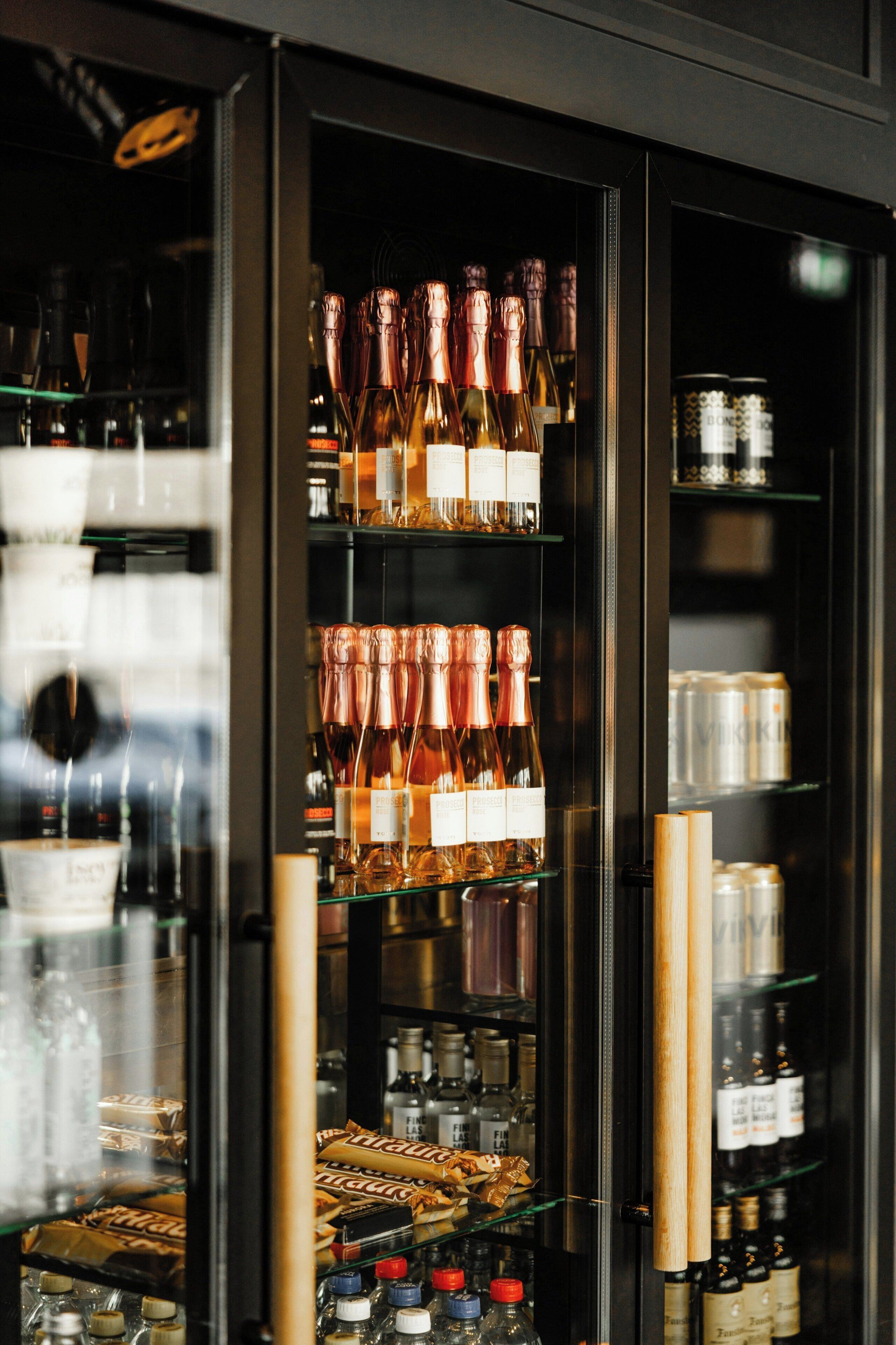 A bar area with shelves stocked with bottles and glasses.