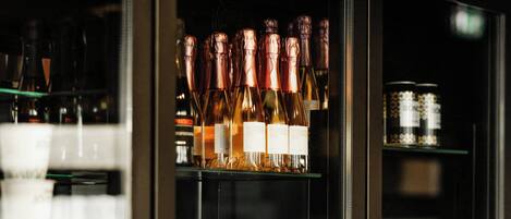 A bar area with shelves stocked with bottles and glasses.