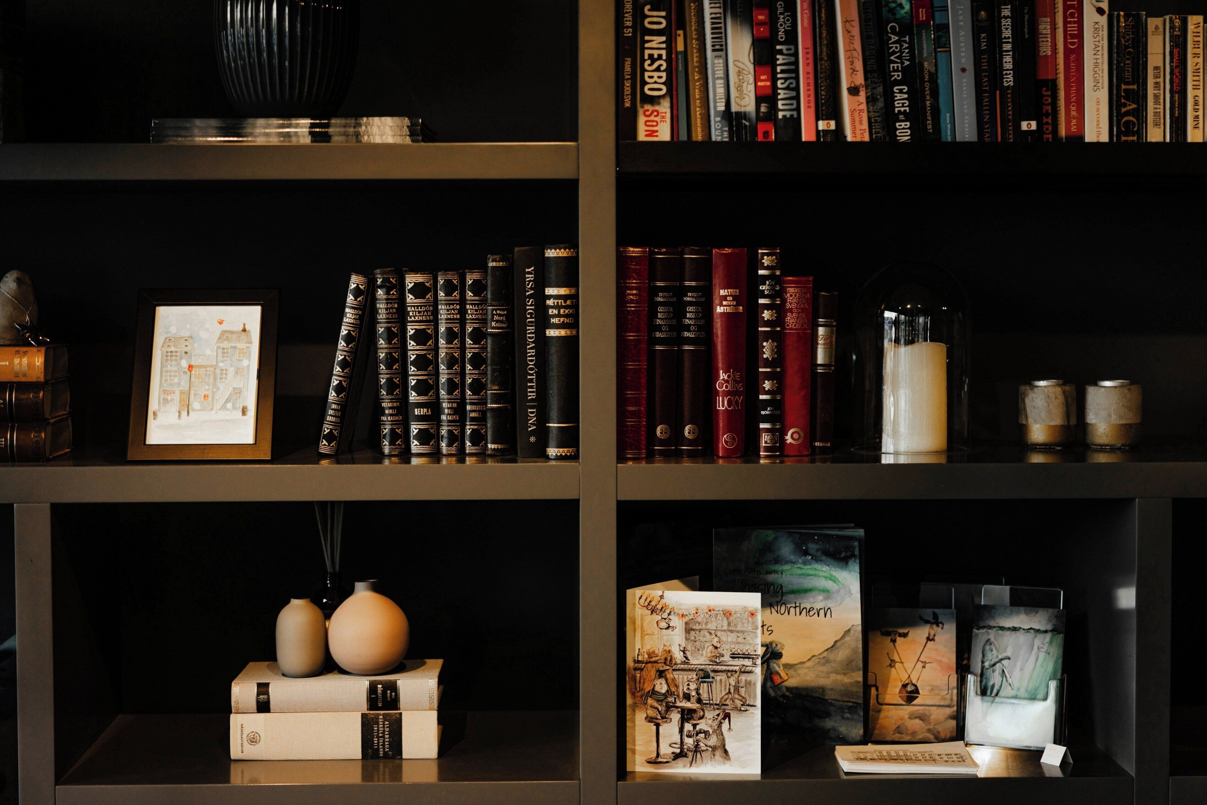 Una estantería con varios libros, un cuadro enmarcado y objetos decorativos.