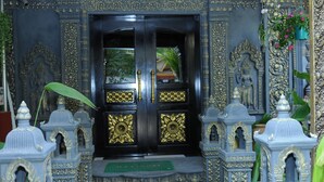 A black door with gold accents, flanked by ornate blue and gold pillars, leading to a temple-like interior. - Popular Boutique Hotel (Siem Reap)