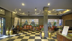 A lobby with a checkered floor, wooden furniture, and decorative columns. - Popular Boutique Hotel (Siem Reap)