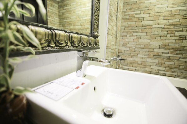 A bathroom with a white bathtub, a mirror, and a tiled wall. - Popular Boutique Hotel (Siem Reap)