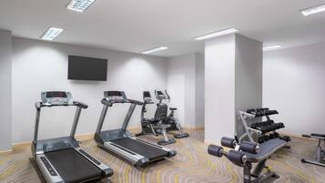 A gym with treadmills, elliptical machines, and weightlifting equipment.