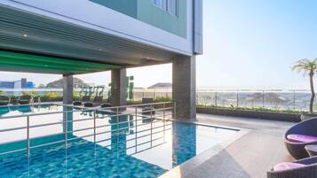 Una piscina techada, sillones reclinables de piscina
