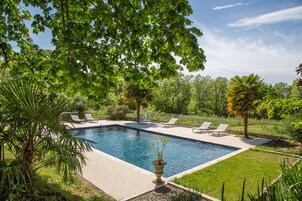 Una piscina al aire libre de temporada, tumbonas