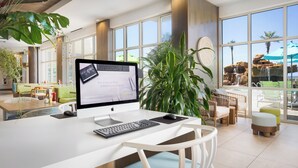 A modern hotel lobby with a large desk, computer, and seating area. - Holiday Inn Resort Fort Walton Beach by IHG (Fort Walton Beach)