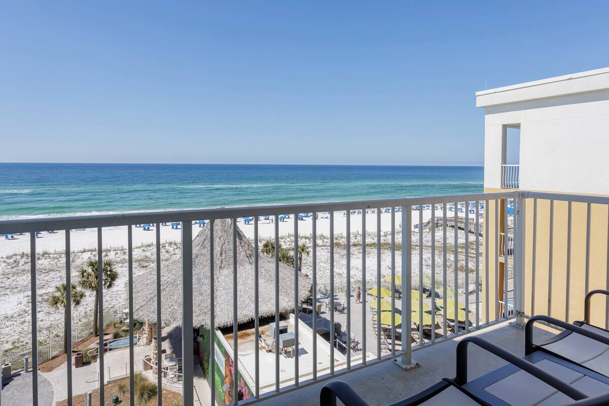 A balcony with a view of a beach and ocean.