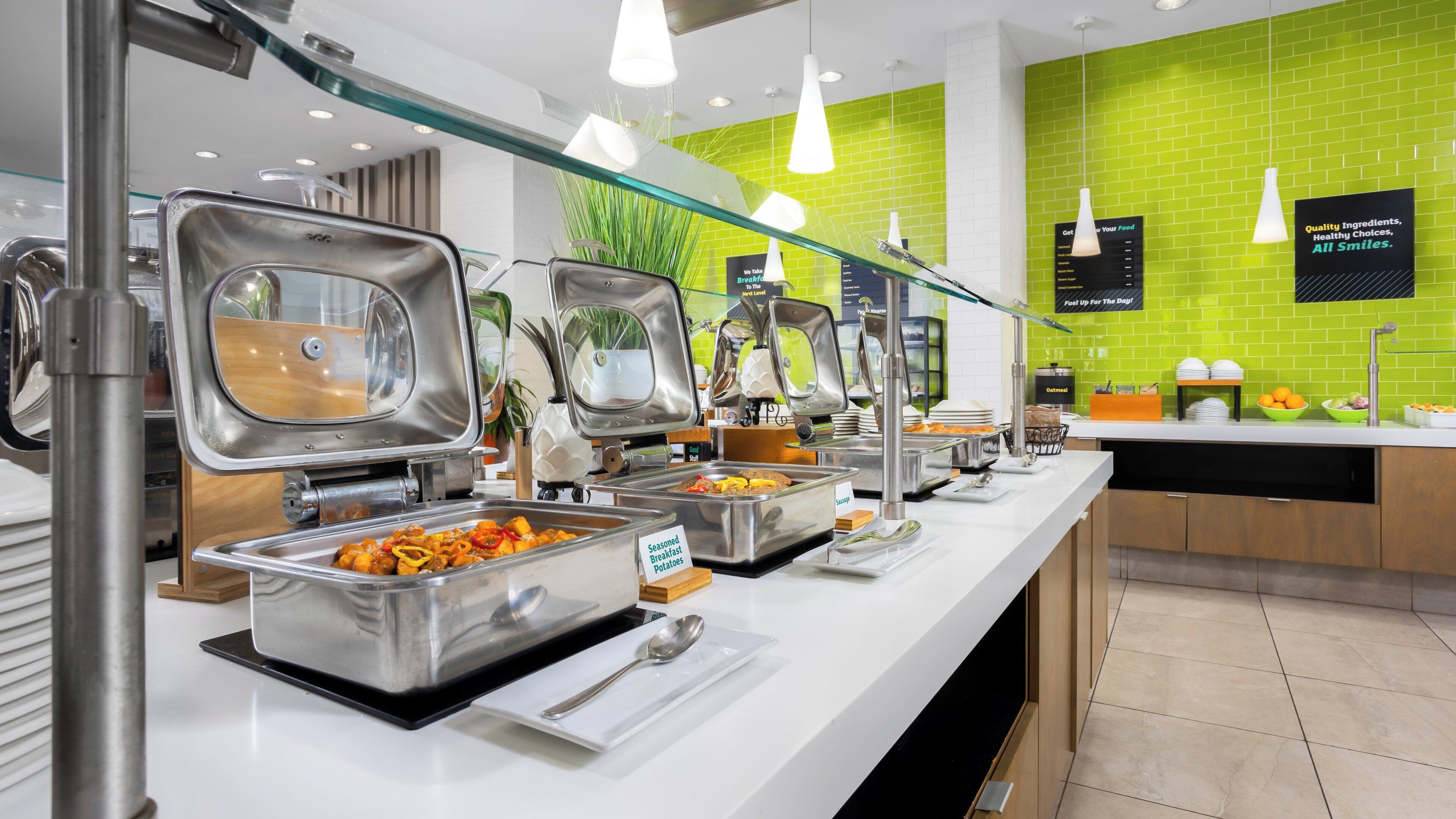 A buffet area with various food stations, including a section for seasoned breakfast potatoes.