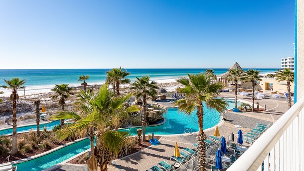 A resort pool area with palm trees, a beach view, and a clear blue sky. - Holiday Inn Resort Fort Walton Beach by IHG (Fort Walton Beach)