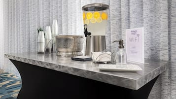 A hotel reception desk with a water dispenser, a scale, a tray, and a sign indicating WIFI availability.