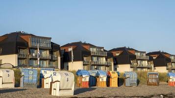 Beach houses with numbered beach huts in front.
