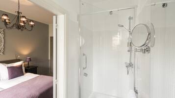 Un baño moderno con cabina de ducha de vidrio, bañera y ducha de mano.