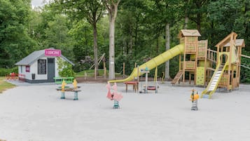 A playground with a yellow slide, climbing structures, and a small building labeled 'LISHOFKE'.