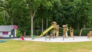 A playground with slides and swings, a small building labeled 'USHOFKE', and a green trampoline.