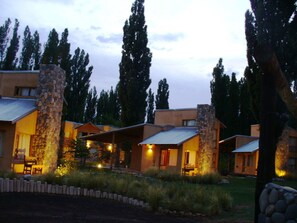 A modern resort with stone pillars, multiple cabins, and a well-maintained garden. - Monte Coiron (Malargüe)