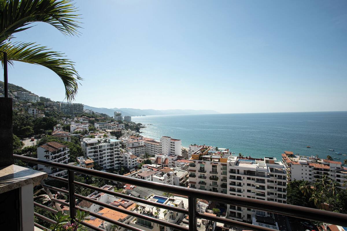 A coastal cityscape with buildings overlooking the sea, featuring a mix of residential and commercial structures.
