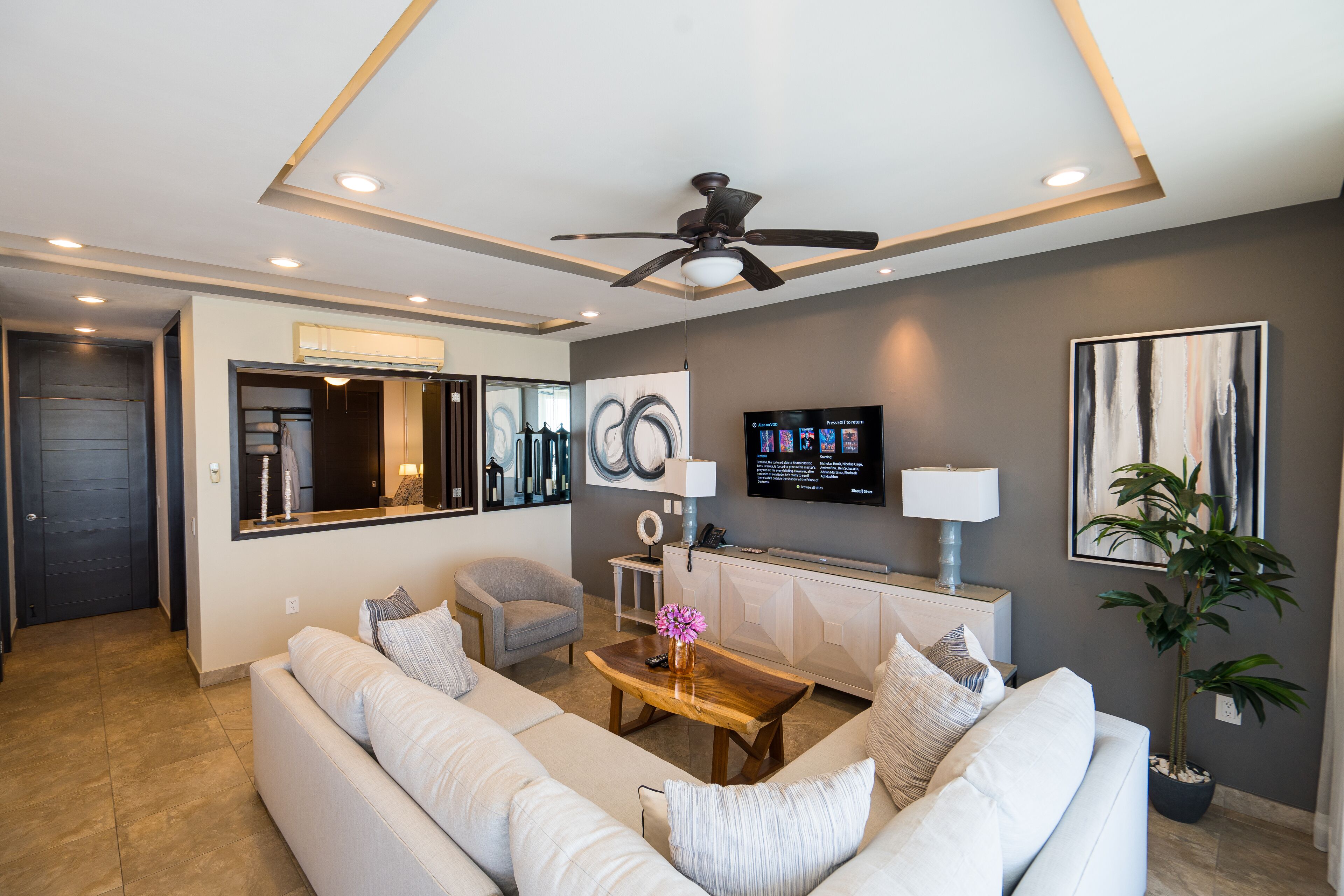 A modern living room with a sofa, coffee table, and a ceiling fan.
