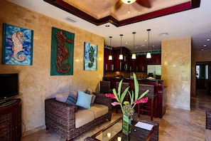 A living room with a sofa, a coffee table, and artwork on the walls.