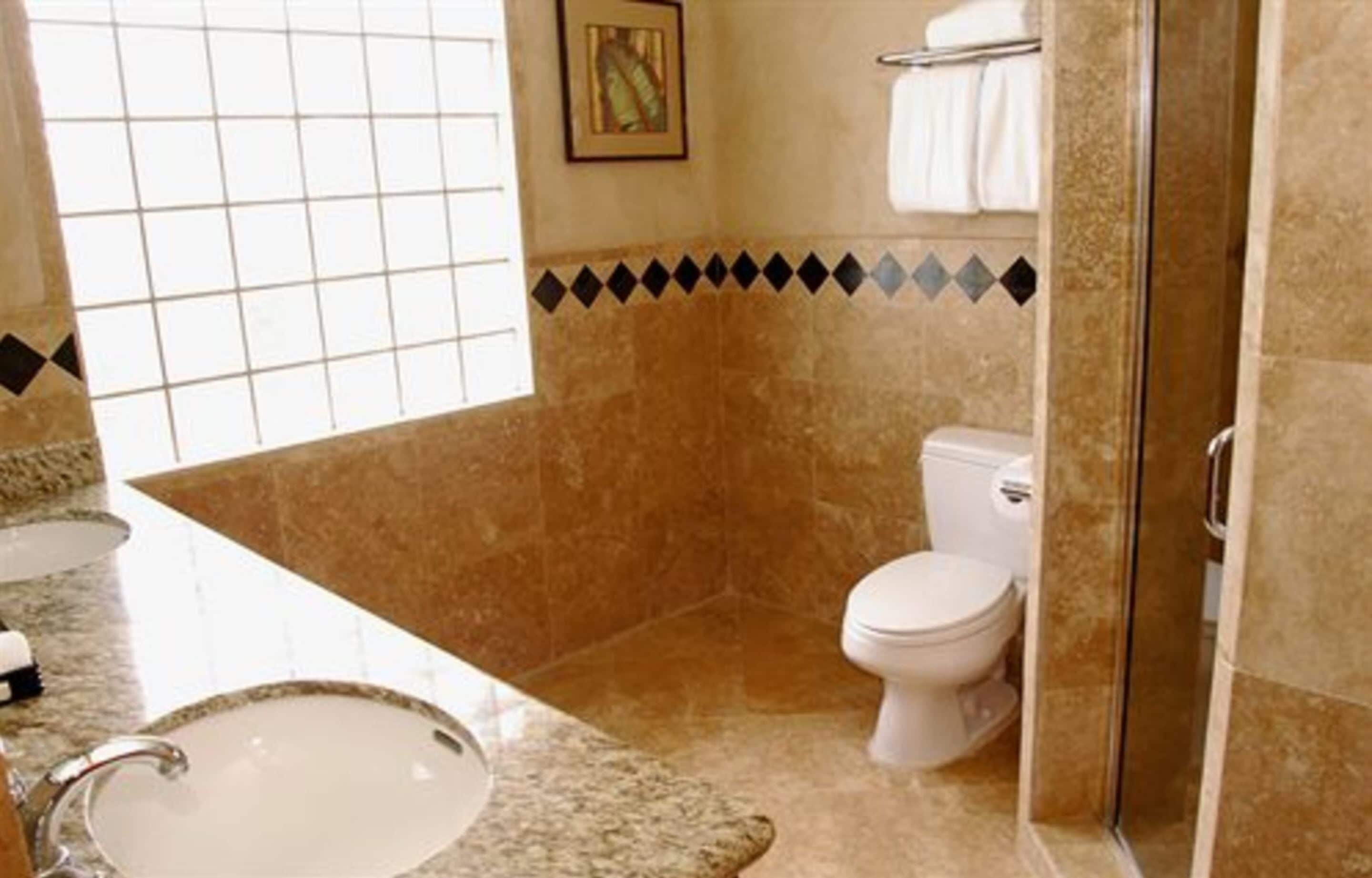 A bathroom with a sink, toilet, and shower.