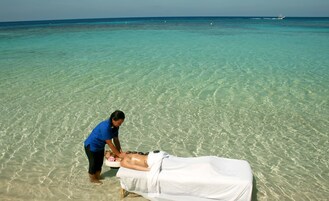 På stranden, vit sandstrand, solstolar och parasoller