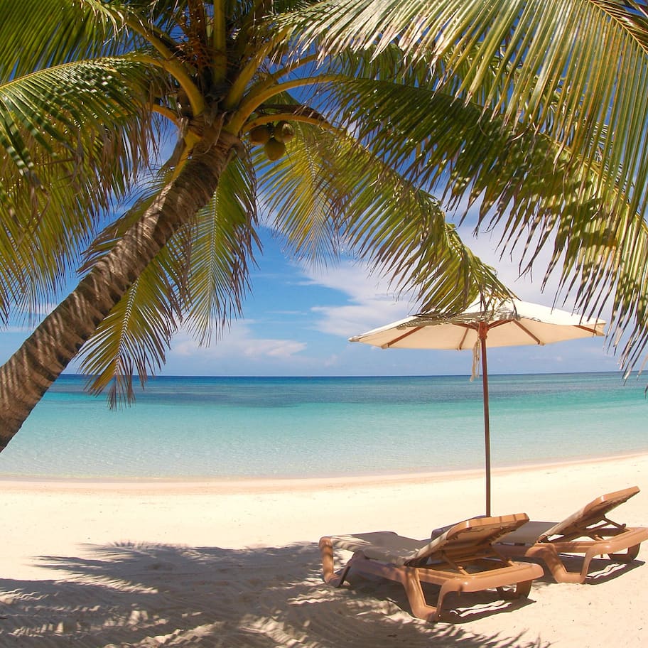 On the beach, white sand, sun loungers, beach umbrellas