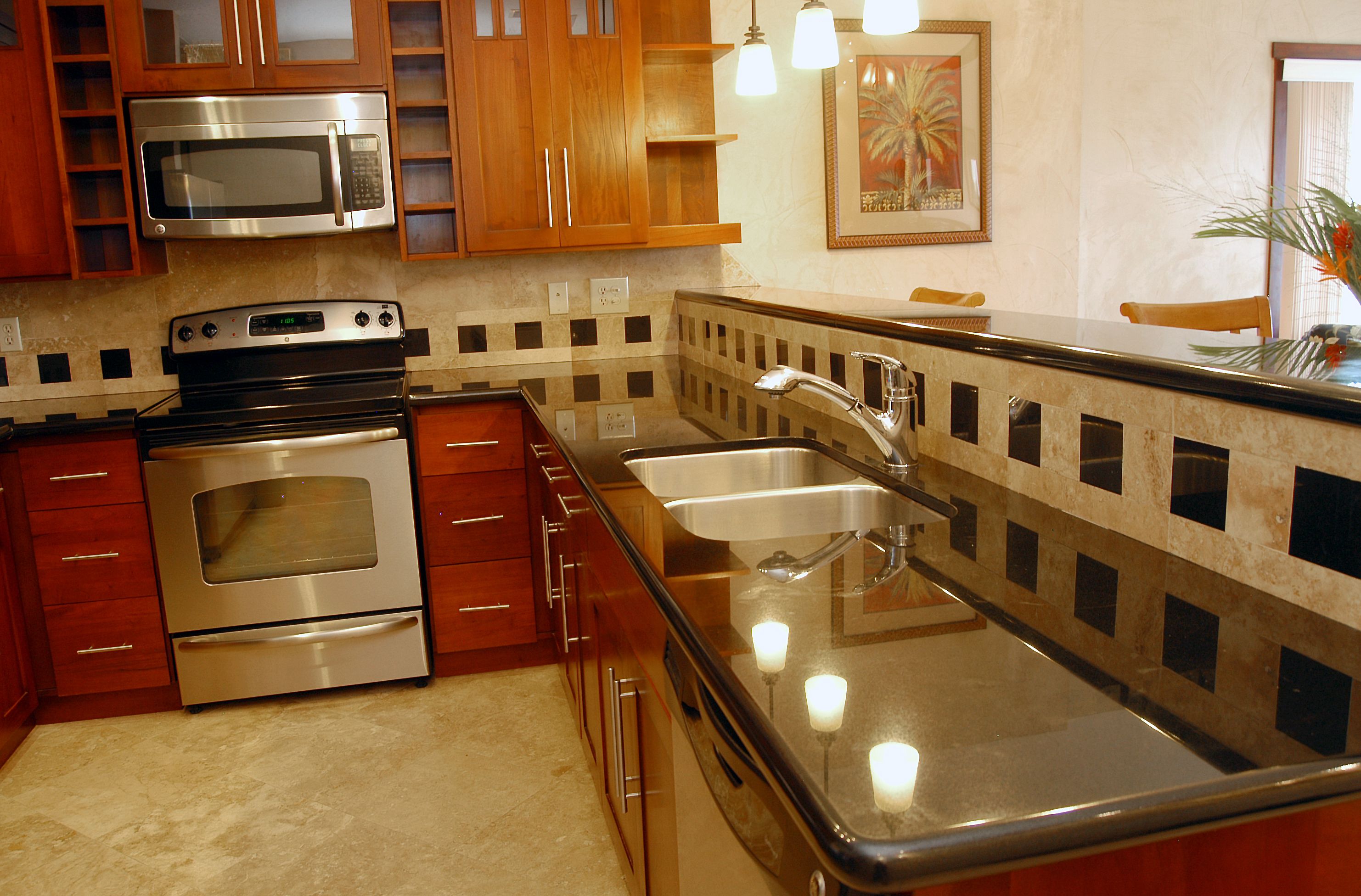Una cocina con armarios de madera, electrodomésticos de acero inoxidable, un lavamanos doble e iluminación colgante.