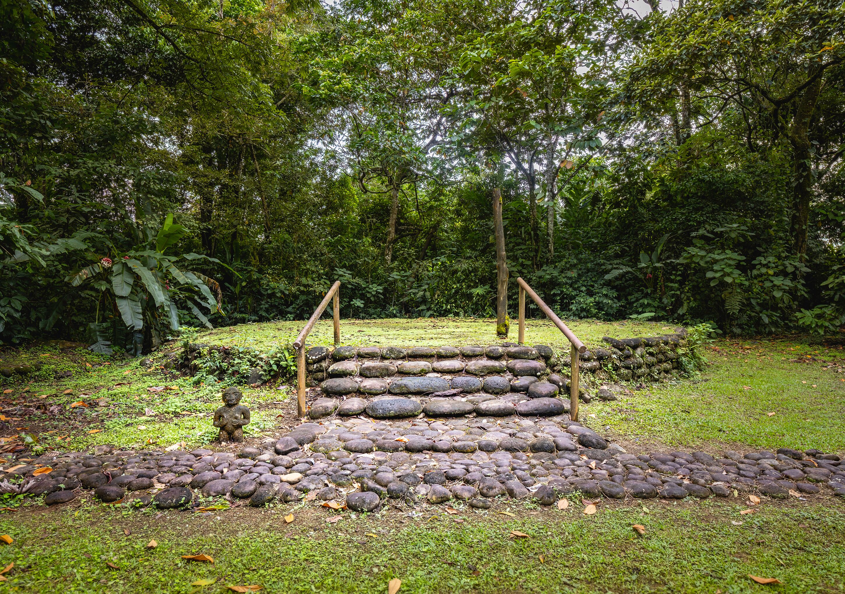 A stone staircase leading up to a wooden structure surrounded by lush greenery.