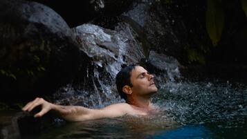 A person in a natural setting with water flowing over rocks.