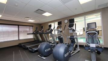 A gym with treadmills, elliptical machines, and a stationary bike.
