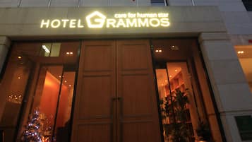 Hotellin sisäänkäynti, jossa on kyltti, jossa lukee ”HOTEL RAMMOS”, ja useita lippuja.
