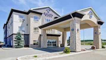 Hotel entrance features a covered walkway supported by stone pillars.