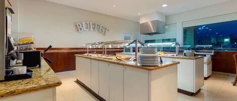 A buffet area with a marble countertop, multiple serving stations, and a sign that reads "BUFFET".