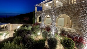 Un edificio de piedra con ventanas de arco y una pérgola.