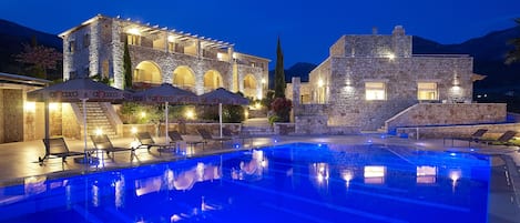 Una piscina al aire libre de temporada, sombrillas, tumbonas