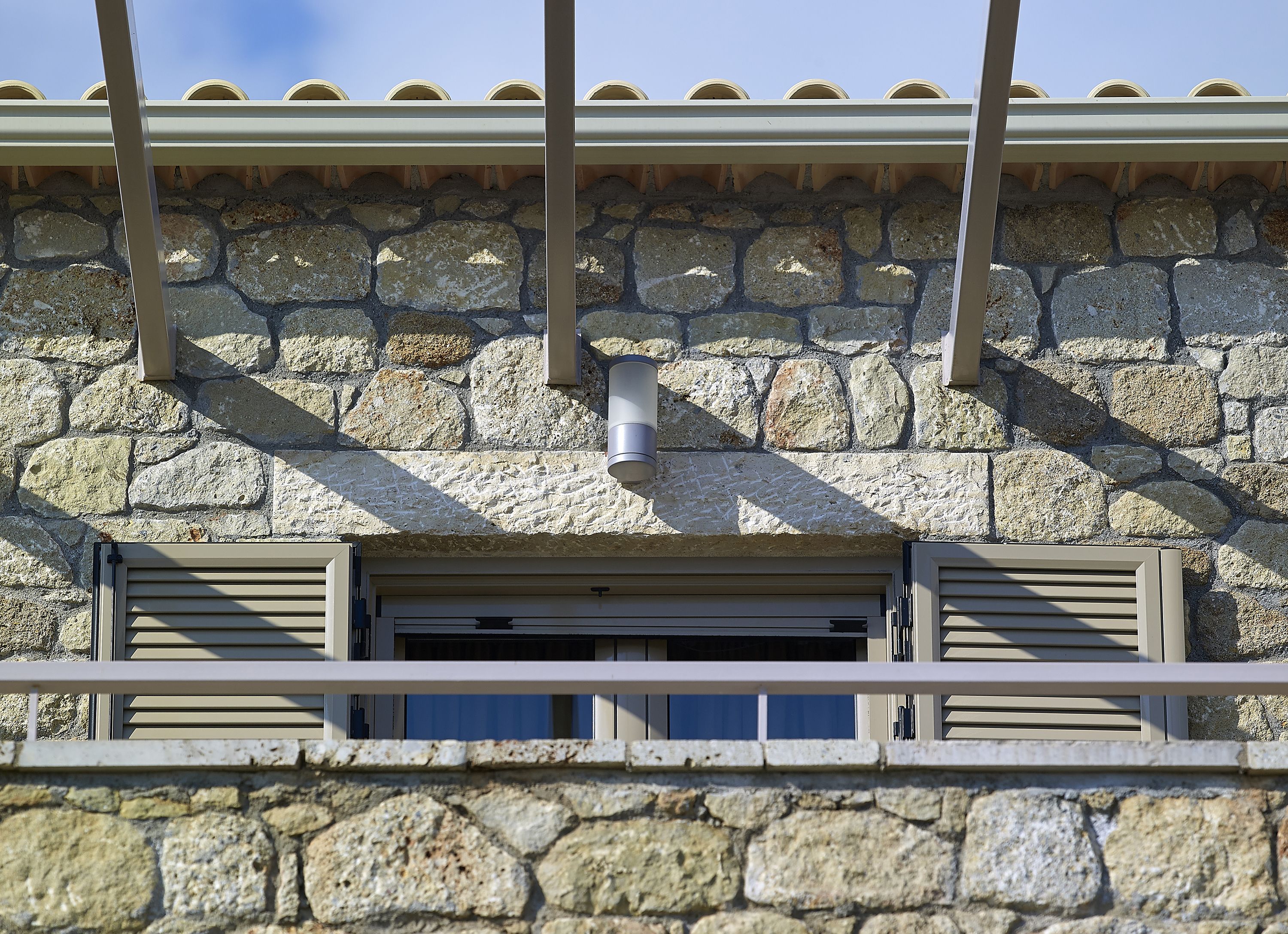 Un bâtiment en pierre doté d’une fenêtre et d’un système de ventilation.