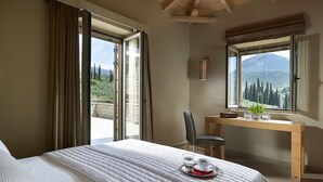 Un dormitorio con cama, escritorio y vistas a un paisaje montañoso.