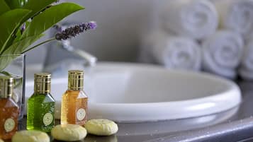 A bathroom counter with toiletries, a sink, and towels.