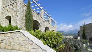 Un edificio de piedra con ventanas de arco y una pérgola de madera.