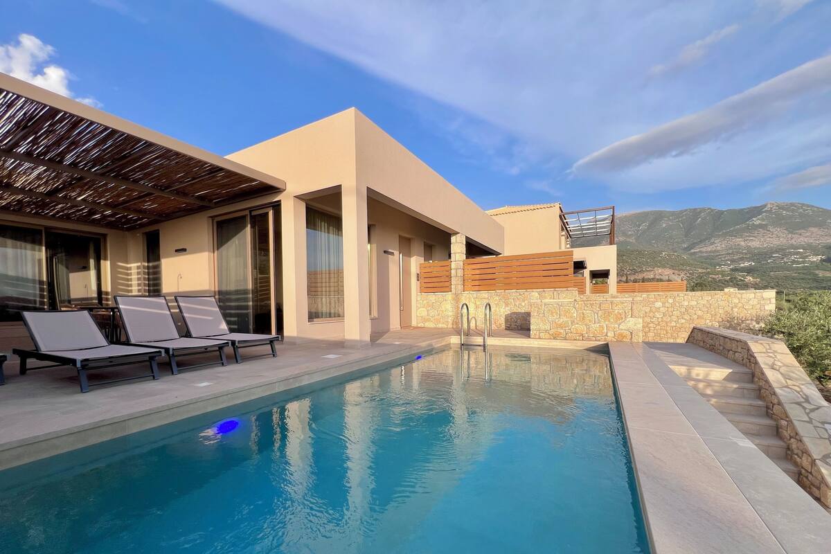 Ein moderner Poolbereich mit Liegestühlen und Bergblick.