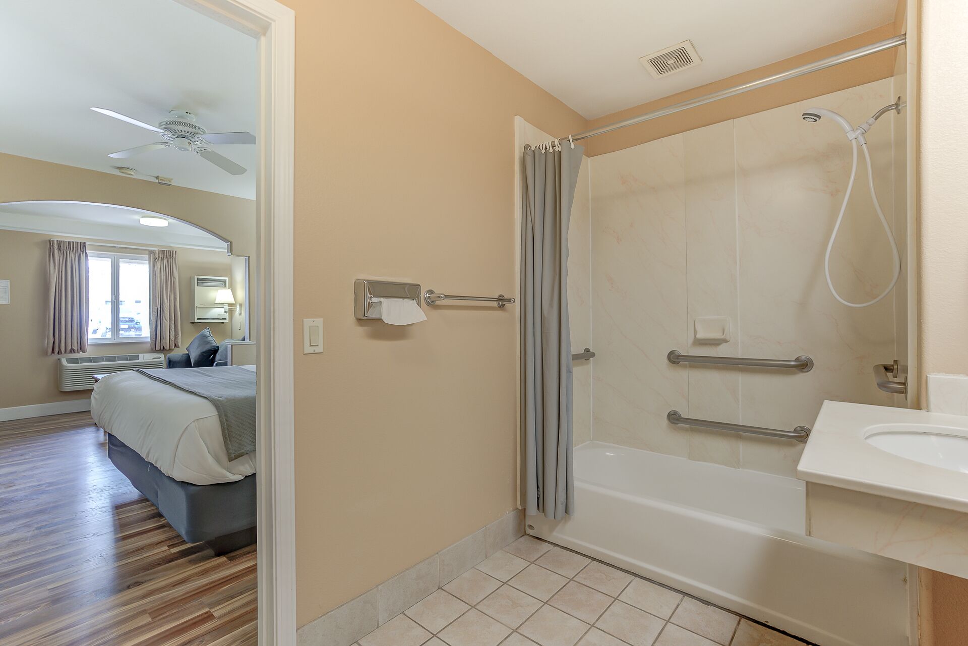 A hotel bathroom with a shower, a bathtub, and a sink.
