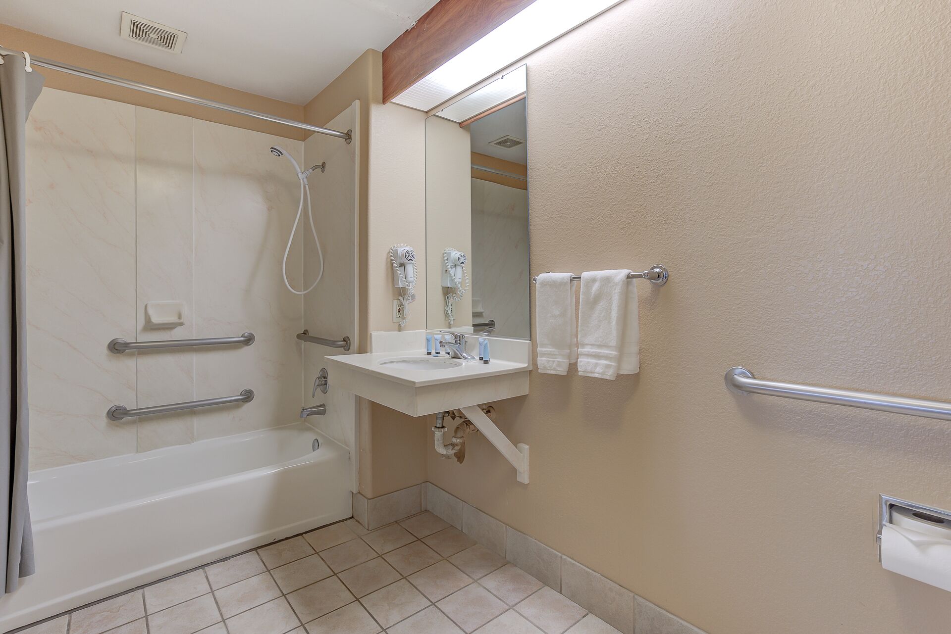A bathroom with a bathtub, a shower, a sink, and a mirror.