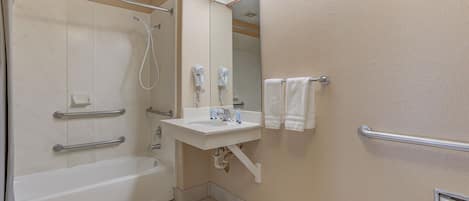 A bathroom with a bathtub, a shower, a sink, and a mirror.