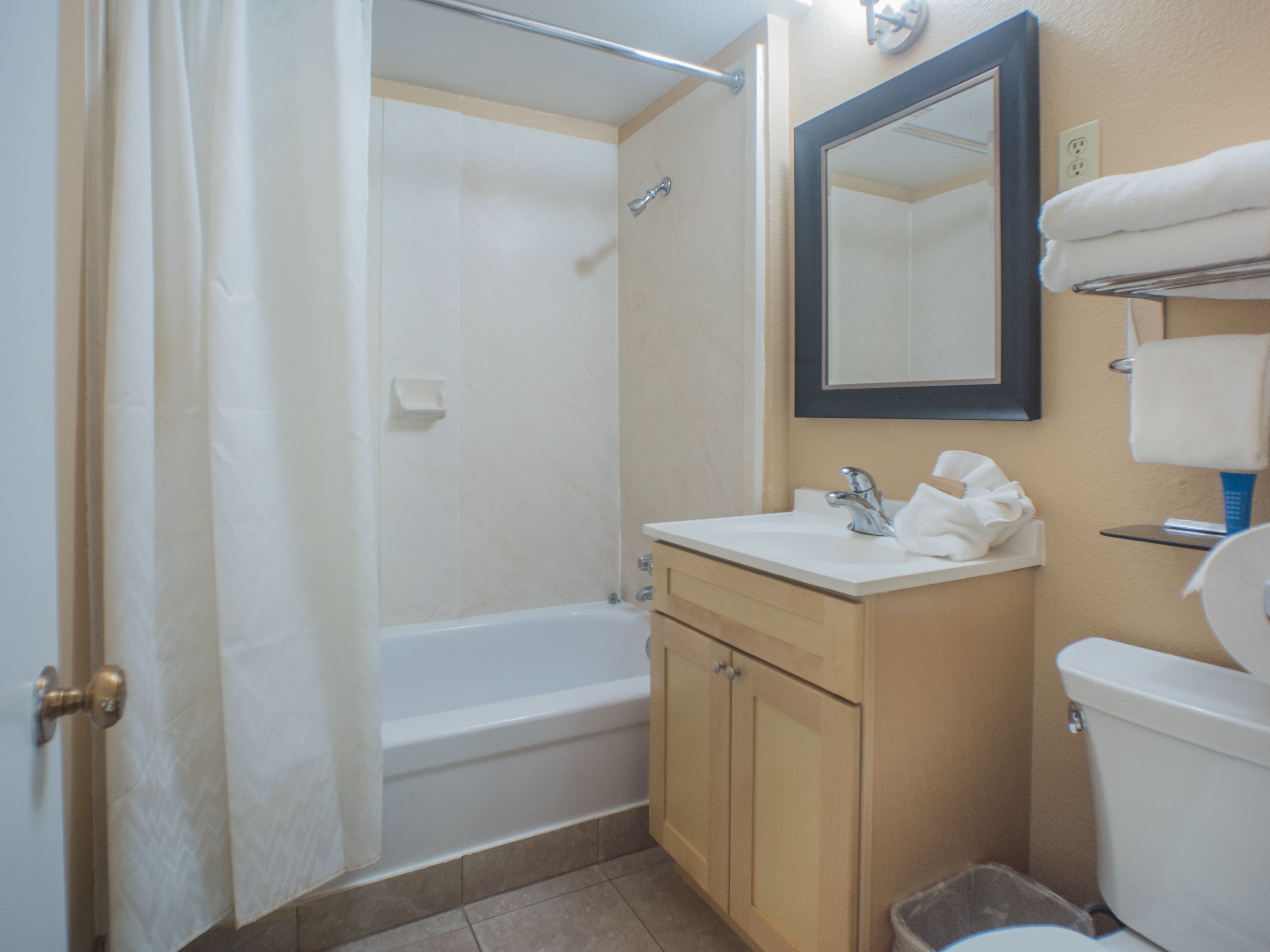 Un baño con bañera, lavabo, espejo e inodoro.