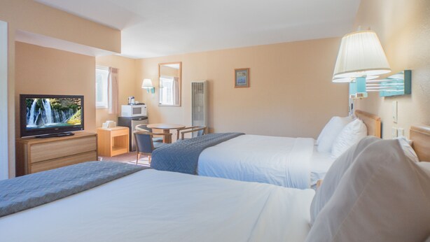 A hotel room with two beds, a television, a desk, and a chair. - Shasta Pines Motel & Suites (Burney)