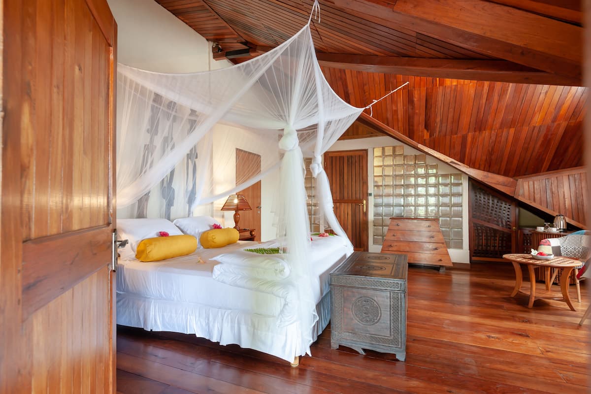 Une chambre à coucher avec un lit à baldaquin, un plancher en bois et un plafond en bois de style traditionnel.