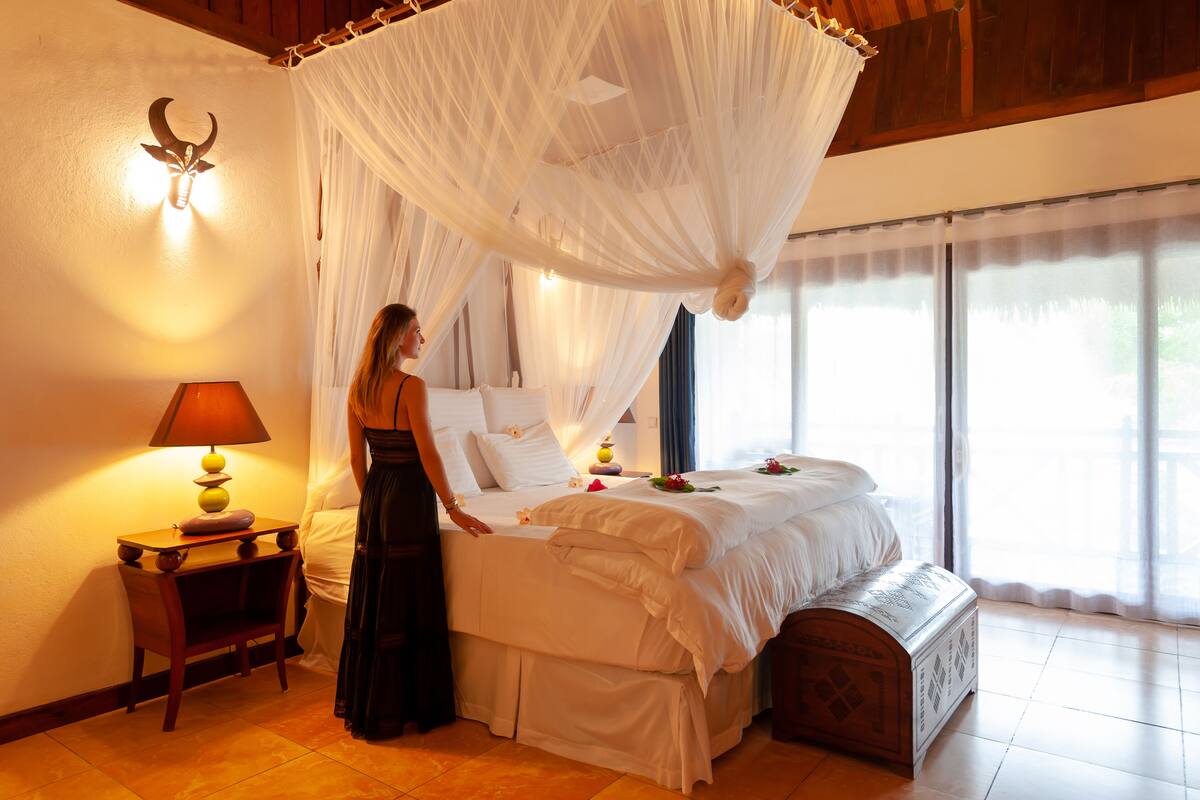Une chambre à coucher avec un lit, une table de chevet, une lampe et un lit à baldaquin.