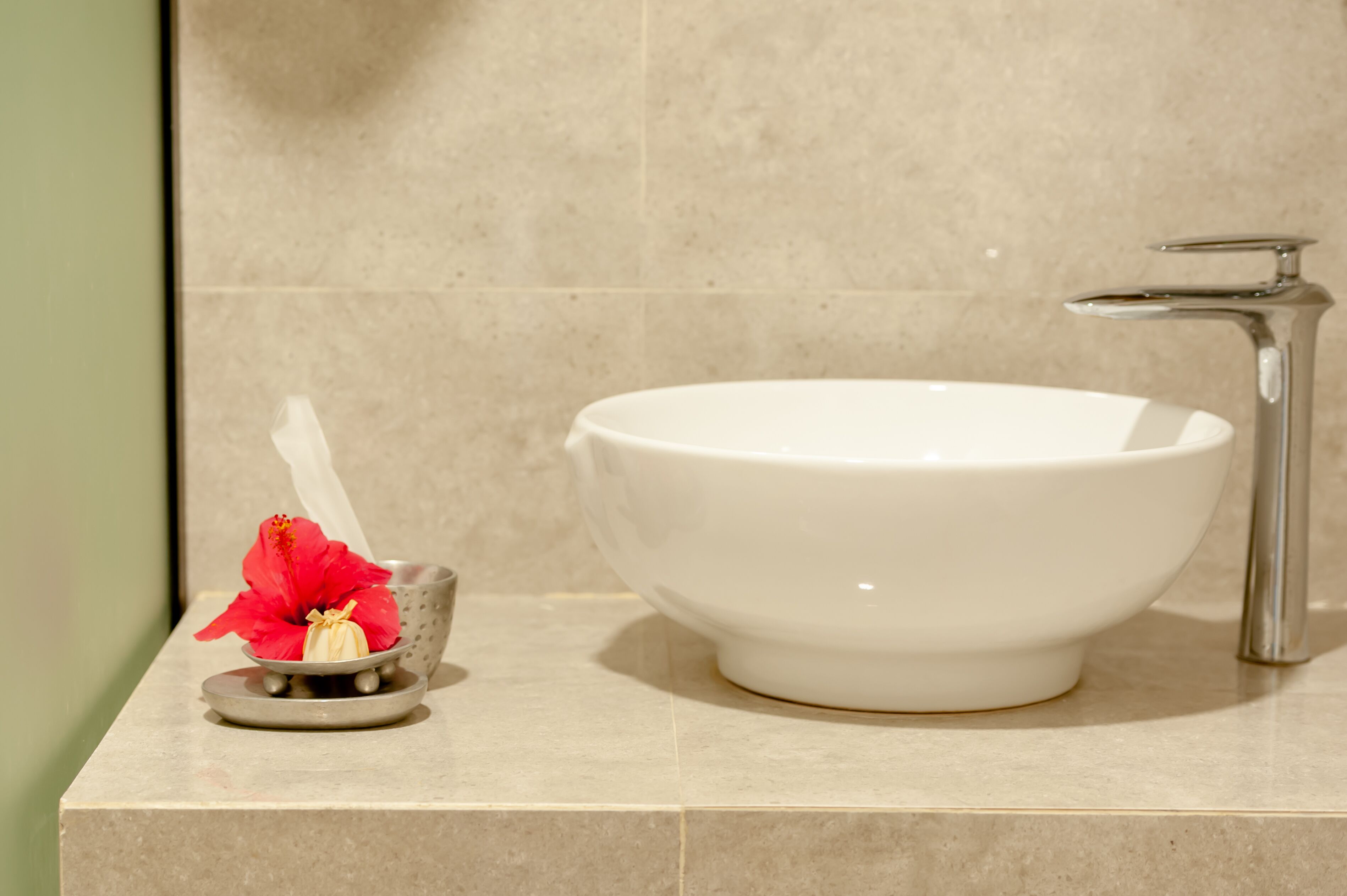 A white sink with a modern faucet on a beige countertop.